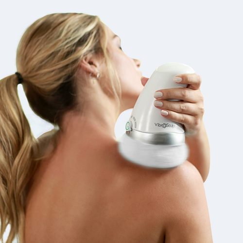 Mujer usando Vibro Sculpt en la espalda para masaje relajante.